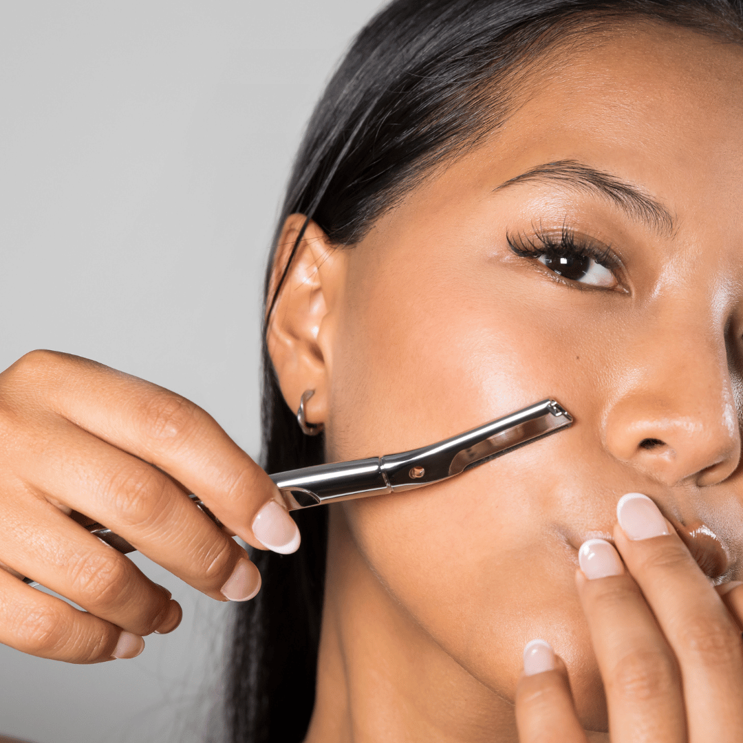 Close-up of Make My Shave's metal face razor gliding over woman's cheek removing facial hair