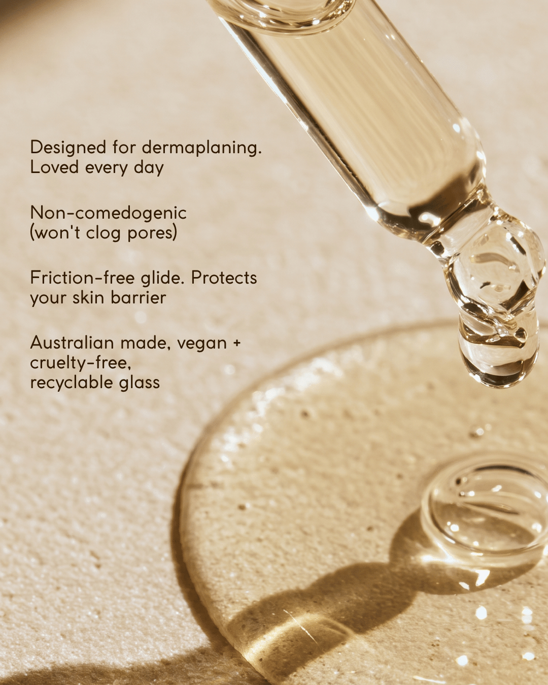 A close-up of a glass dropper containing dermaplaning facial oil serum above a circular glass dish on a warm beige surface, with black text describing product benefits.