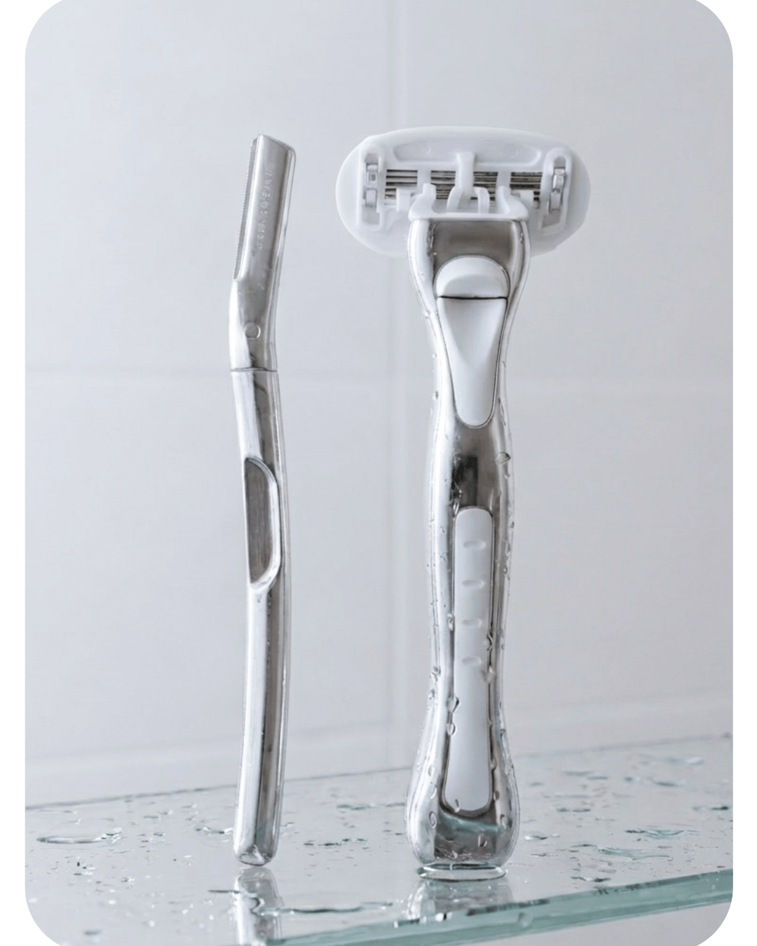 Metal dermaplaner and womens razor on a reflective surface with a light gray background by the brand Make My Shave
