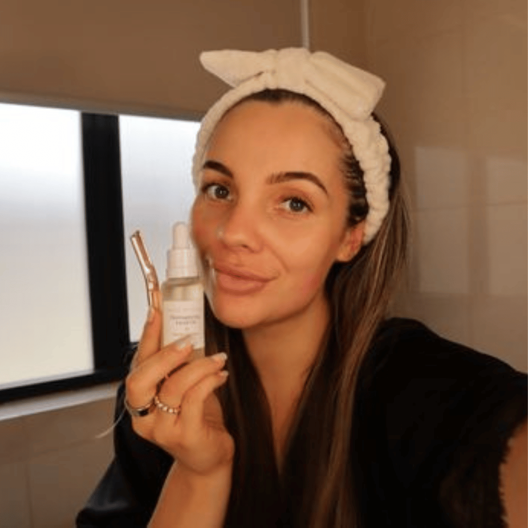 Woman holding a dermaplaning bundle australia while in her bathroom