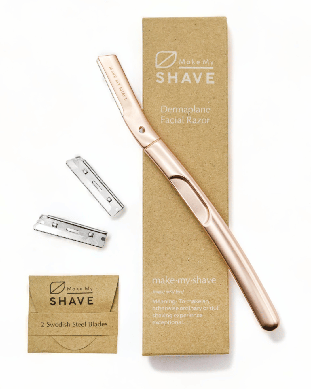 A rose gold dermaplaning tool with two silver steel blades, displayed next to its brown kraft paper packaging box and a small kraft refill blade and the text Make My Shave. 