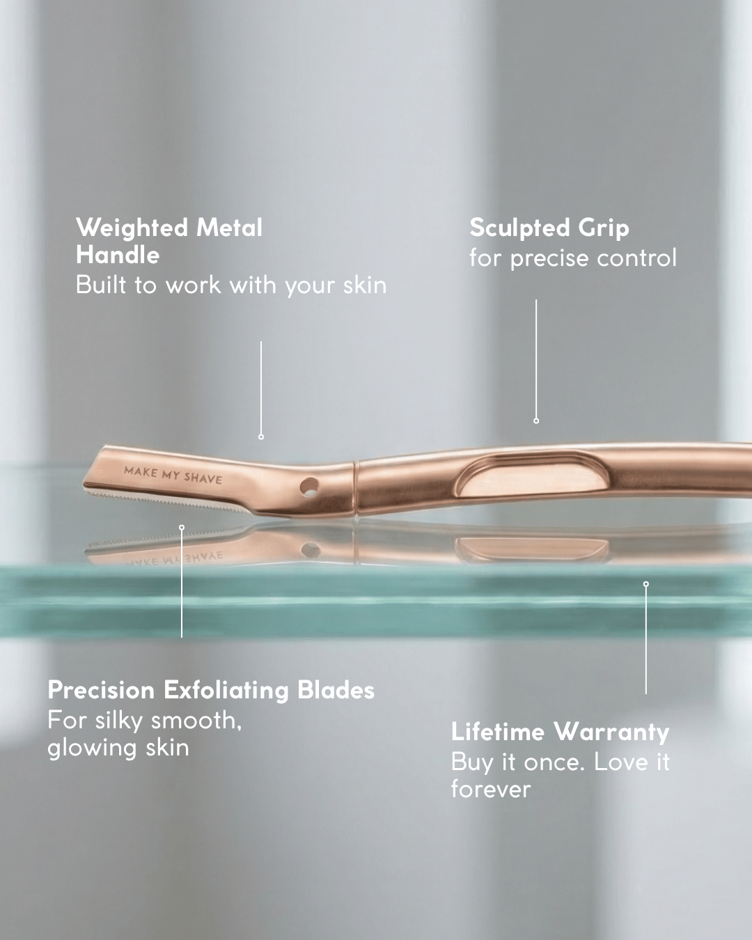 Rose gold at-home dermaplaning tool with callout text labels pointing to the weighted metal handle, sculpted grip, precision exfoliating blades, and lifetime warranty on a soft grey background.