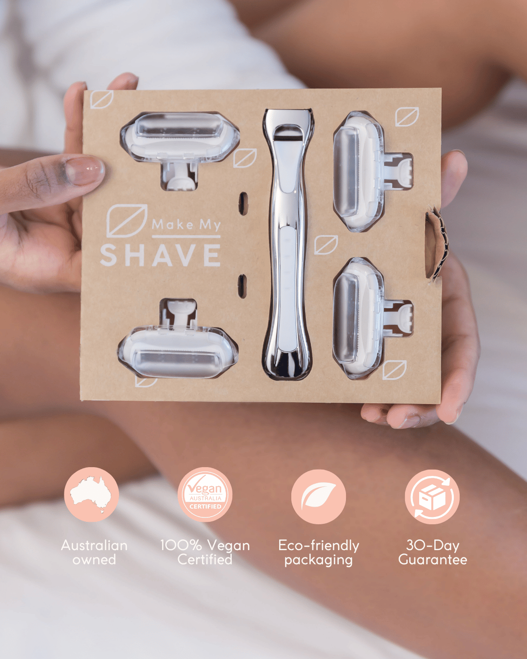 A woman holds kraft packaging containing a silver metal women's razor. The box has the text 'Make My Shave, and shows 5 reusable razor heads and logos showing Australian owned, vegan certified, eco-friendly razor.