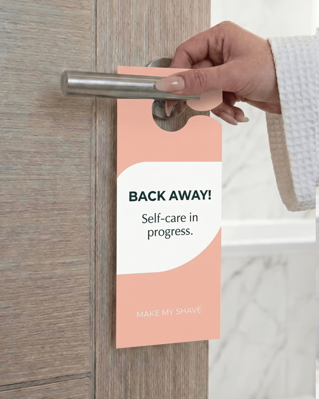 Person holding a door handle with a 'Back Away! Self-care in progress' sign attached.
