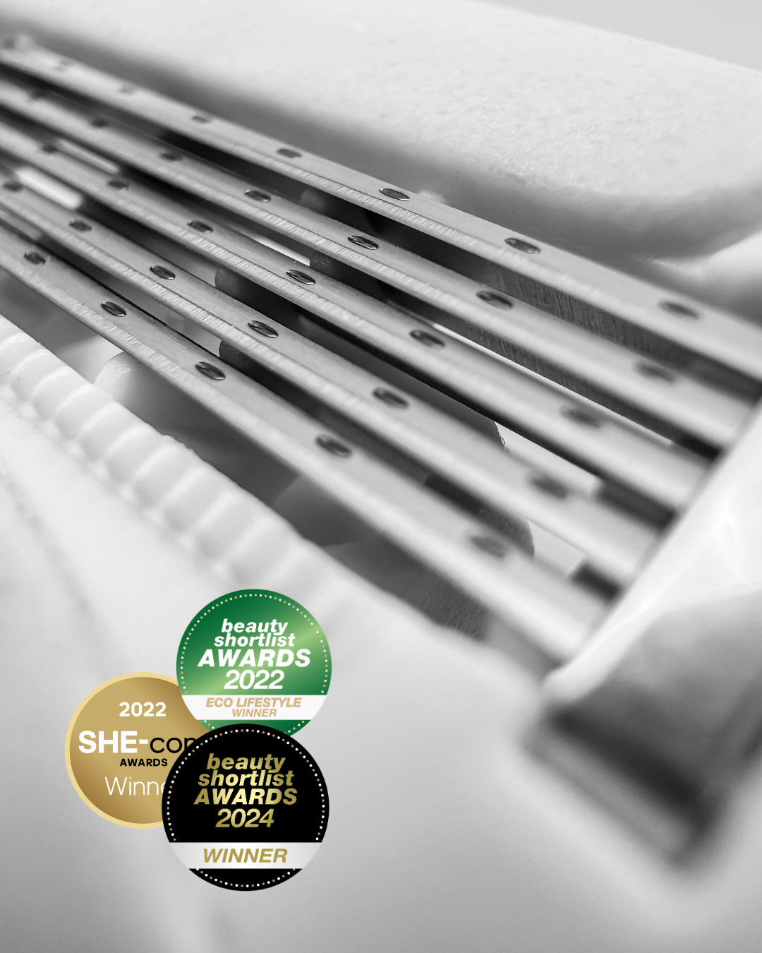 Close up of 5-blade women's razor with awards badges, shows lubrication cushion.